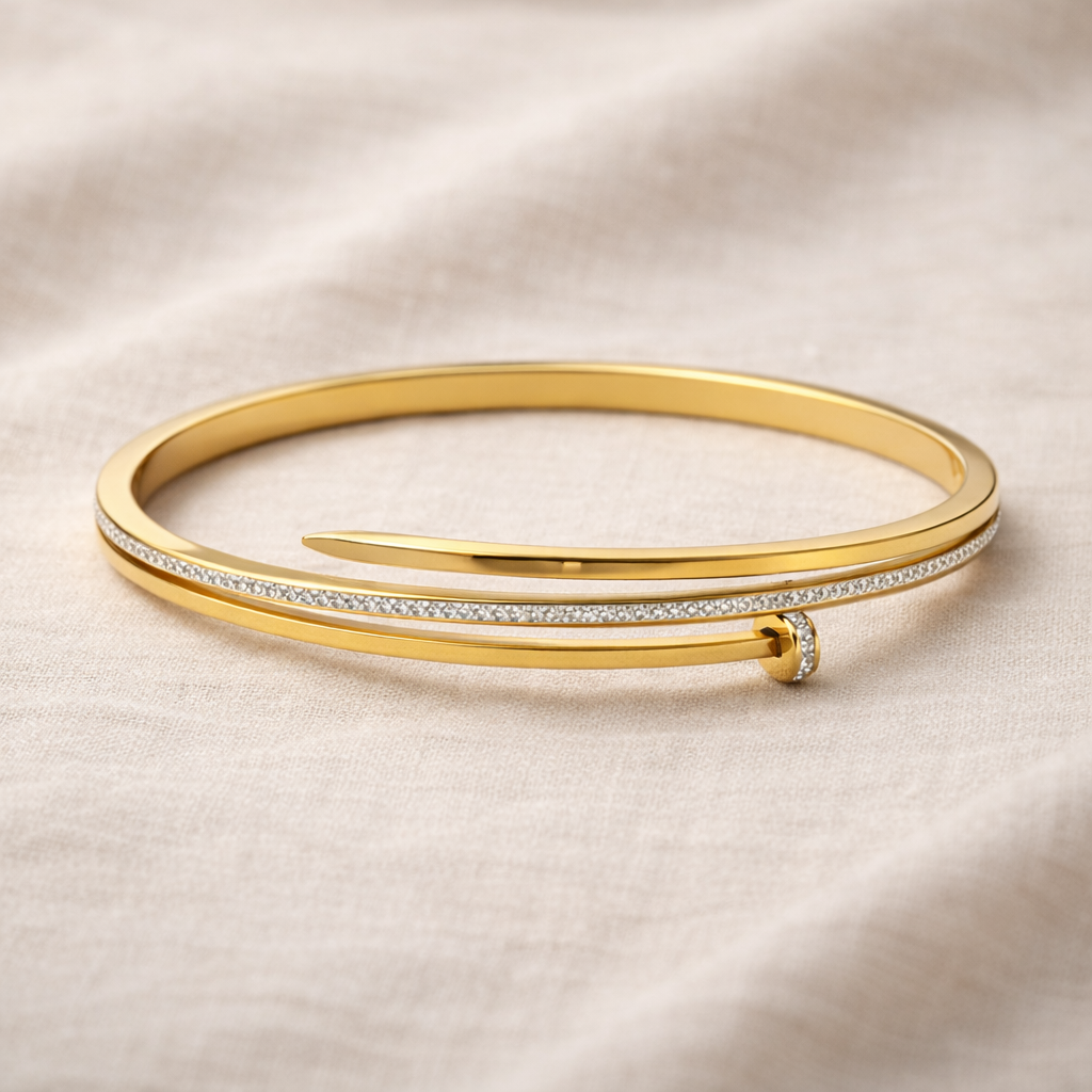 Gold bangle with diamond accents on a beige fabric background