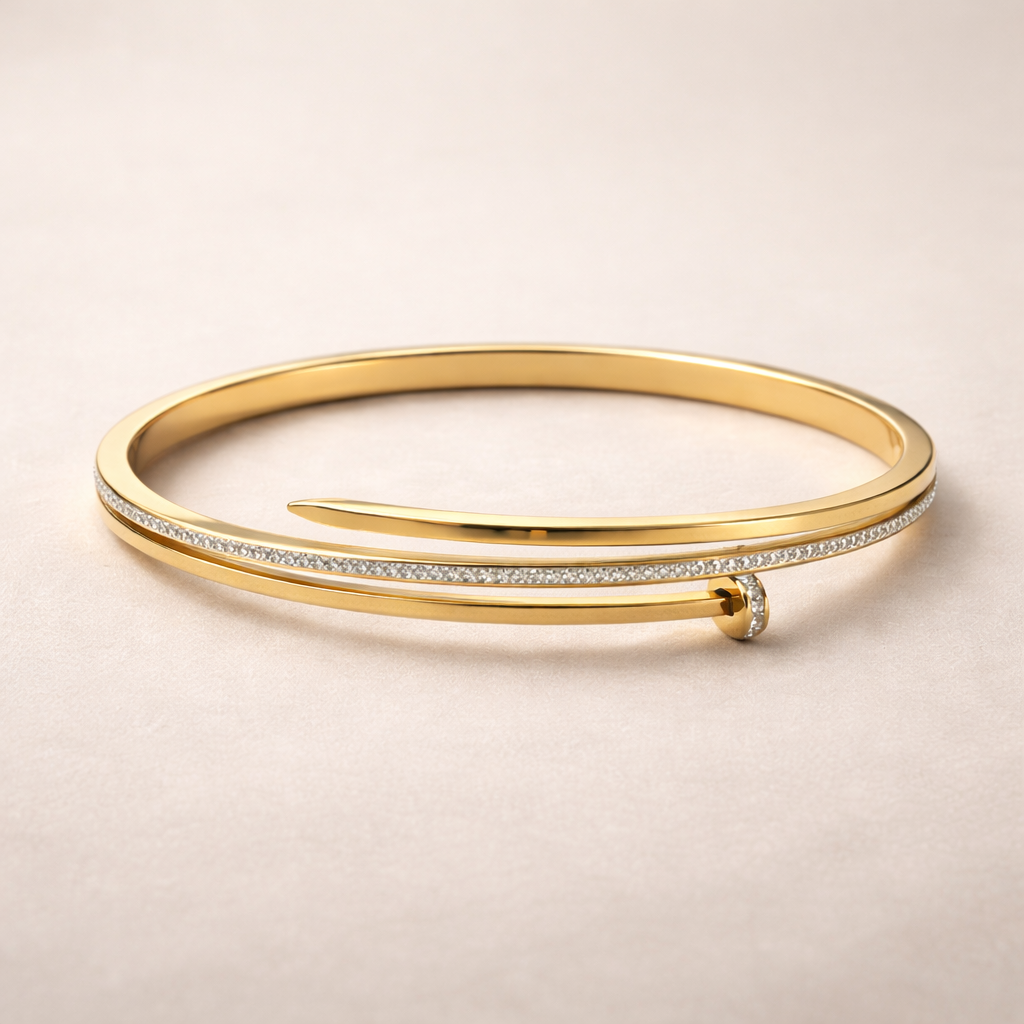Gold bangle with diamond accents on a beige background