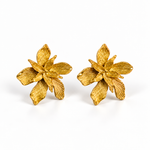 A pair of textured gold flower-shaped earrings on a clean white background.