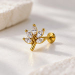 A gold leaf-shaped stud earring with marquise-cut clear crystals, displayed on a soft white textured surface.