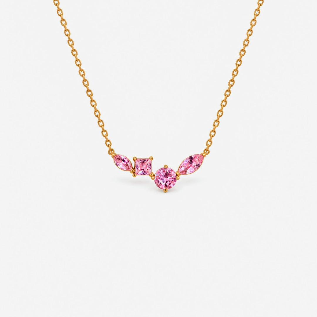 A delicate gold chain necklace featuring a small central cluster of three pink marquise-cut gemstones in a gold setting, shown against a plain light gray background.