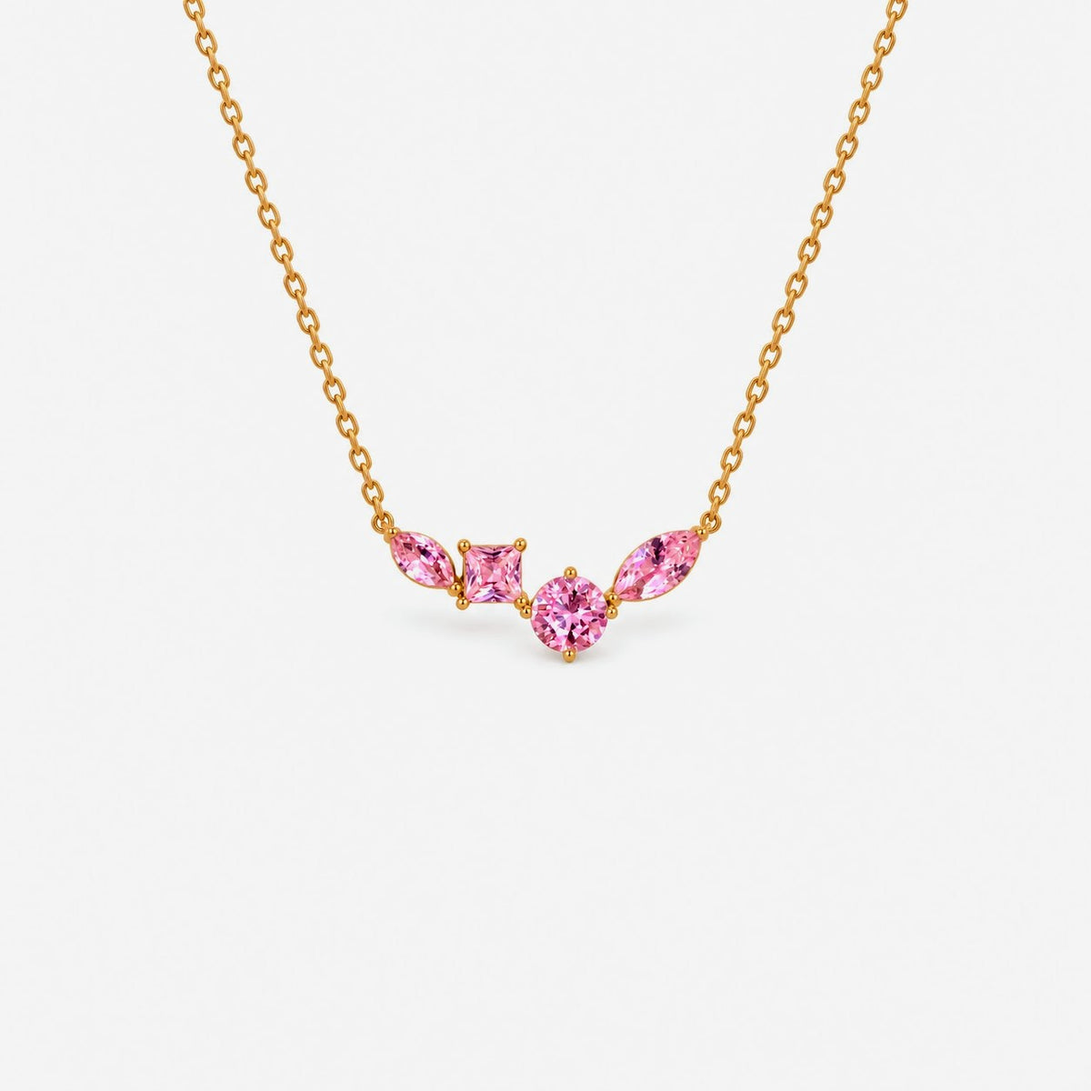 A delicate gold chain necklace featuring a small central cluster of three pink marquise-cut gemstones in a gold setting, shown against a plain light gray background.