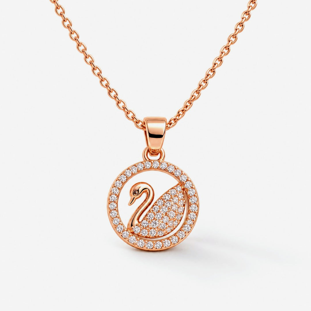 Rose gold necklace with a circular pendant featuring a swan design paved with small clear stones, shown on a light gray background.