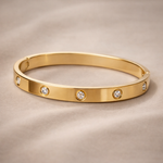 Gold bracelet with diamond accents on a beige background