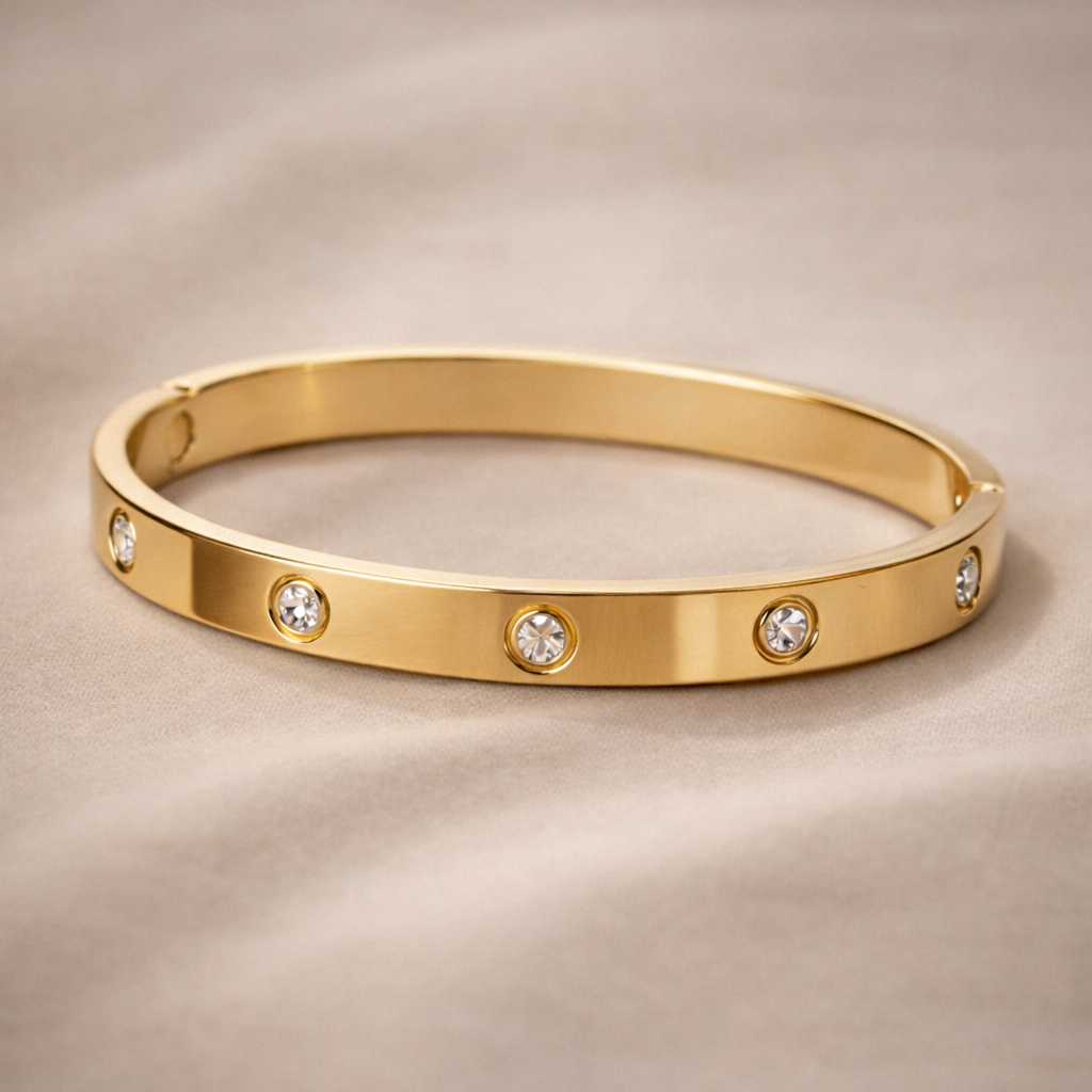 Gold bracelet with diamond accents on a beige background